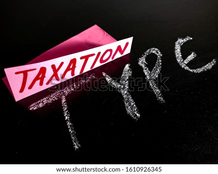 taxation type financial terminology displayed on chalkboard with pink paper slip concept 