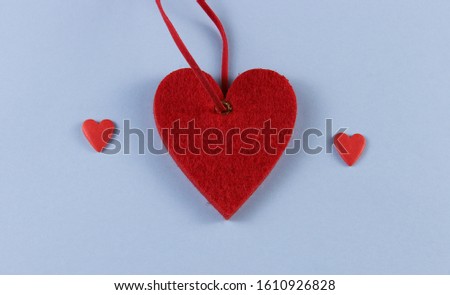 big heart and two small ones on a blue background with place for text.