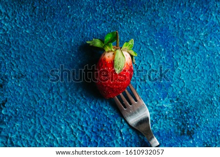 Ripe and juicy strawberry on the dark rustic background. Selective focus. Shallow depth of field.