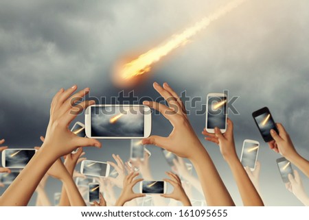 People taking photos of falling meteorite on mobile phone camera