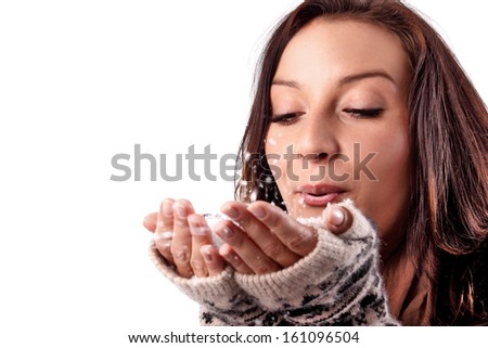 Lovely woman blowing snowflakes