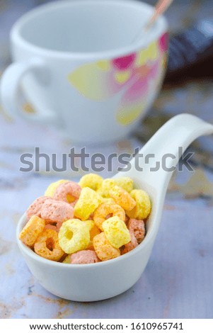 Cereal flakes in white spoon ceramic with copy space,Breakfast concept.Food with delicious fruity taste and fruity colours.It's made with maize,wheat,and barley