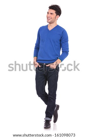 young casual man with hands in pockets looking away from the camera to his side