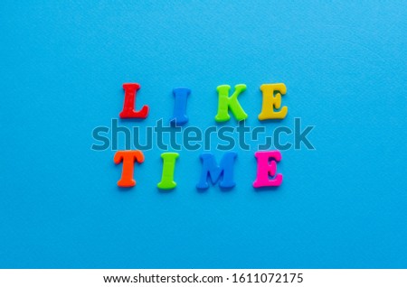 words "liketime" from plastic letters on paper background