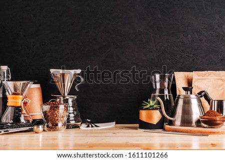 Accessories and utensils for making coffee drinks on a wooden table, coffee shop interior Royalty-Free Stock Photo #1611101266