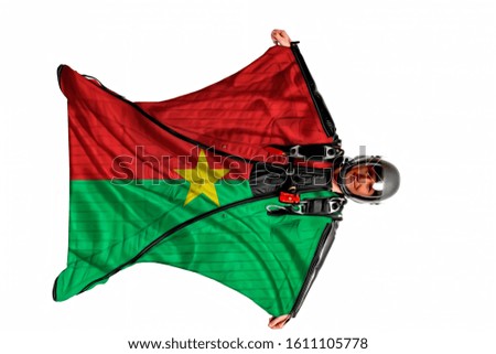 Burkina Faso airport. Bird men in wing suit flag. Sky diving men in parashute. Patriotism, men and flag Burkina Faso.
