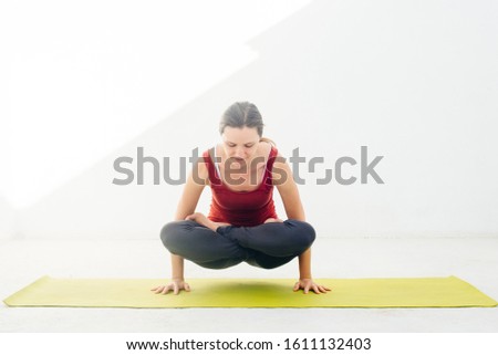Side view portrait of beautiful young woman doing yoga or pilates exercise on white background