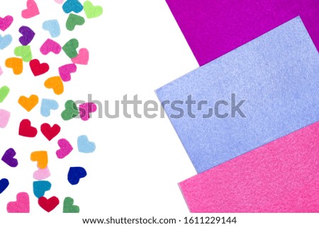 Colorful felt hearts on the white background. Copy space. Place for text and design. Hand made decor. Valentine's card.  Blue, yellow, pink, red, orange, purple, violet, green colors. 