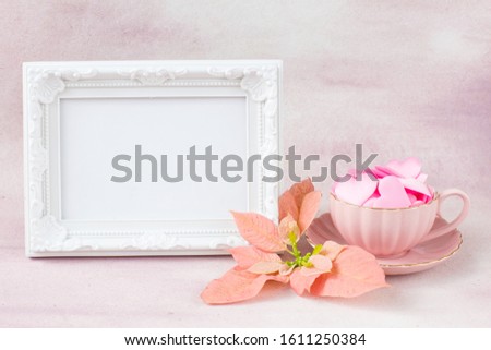 white photo frame, pink poinsettia, pink satin hearts in a pink cup