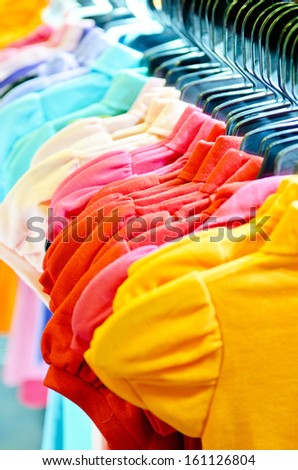 Variety of casual  T-shirts on hangers . Focus Orange T-Shirts . 