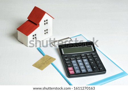 Model of house, credit card and calculator on white background. Buying a home. Concept of mortgage and real estate..