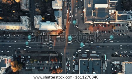 Aerial view of city intersection with many cars and GPS navigation system symbols. Autonomous driverless vehicles in city traffic. Future transportation concept. Royalty-Free Stock Photo #1611270340