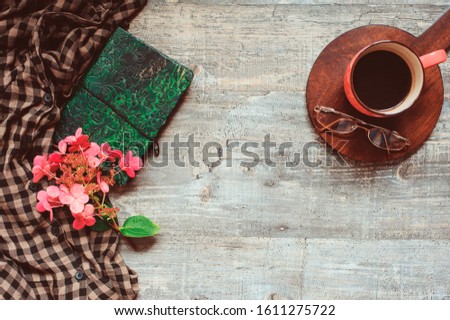 autumn or summer garden table top view with plaid shirt, coffee, dried hydrangea flowers and sketch book