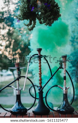 Hookah outdoors on a background of colored smoke.