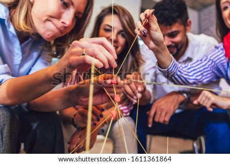 Happy friendly business team having fun at corporate training, funny teambuilding activity, playing spaghetti game. Royalty-Free Stock Photo #1611361864