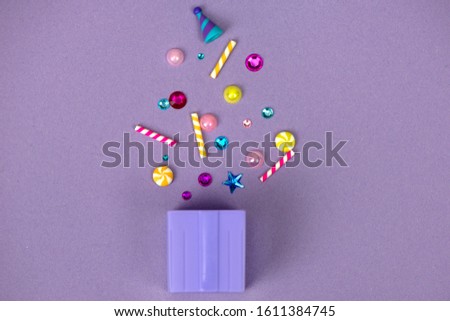 Present with exploding party stuff on a purple background