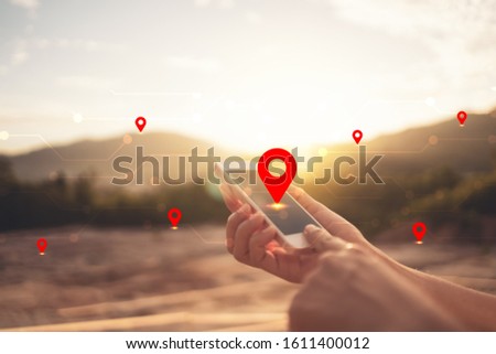 Woman hand using smart phone on top of mountain with navigator location point abstract background. Technology business and travel adventure concept. Vintage tone filter effect color style.