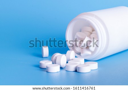 Oral medicine, paracetamol,white pills on blue background Royalty-Free Stock Photo #1611416761