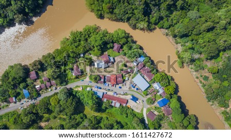 Aerial Drone image of beautiful rural small village with surrounding nature green rainforest at Sabah, Malaysia