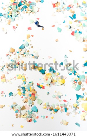 Pieces of eggshell spread over a white background, easter conceptual image, flat lay composition hard natural direct light