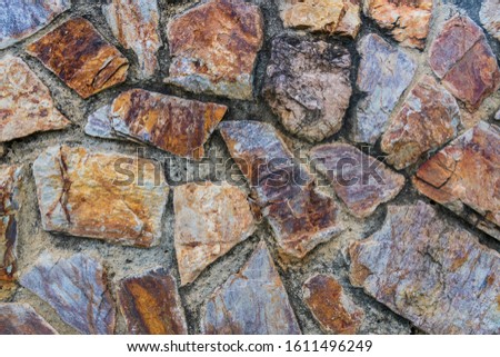 A background photo of a stunning and unique rock wall with a very old fashion design and give an ancient era vibe.