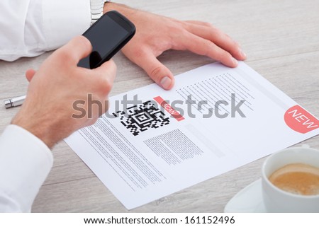 Close-up Of Hand Holding Mobile Scanning Bar Code