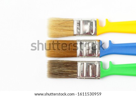 Paint brushes of different colors on a white background close-up, flat lay, place for text.