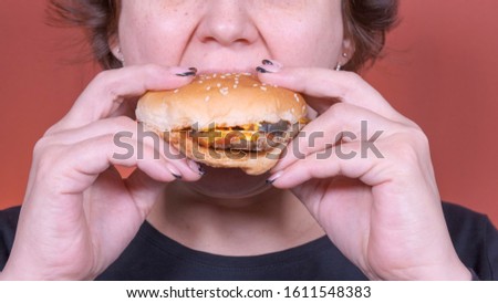 Fast food concept. woman eating a Burger. Close up