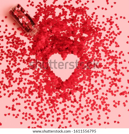 Valentine's Day, love, hearts concept.   Heart shape and red confetti hearts on pastel pink background. 