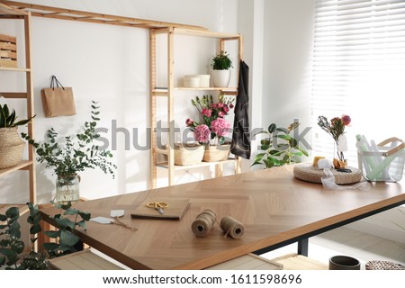 Florist's workplace with fresh flowers and wooden table
