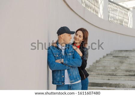 Happy lovers hug on a concrete staircase.