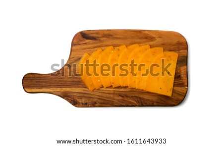 Orange hot cheese with chili pepper and paprika. Sliced cheese with herbs and spices on cutting board isolated top view