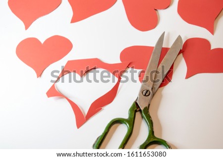 The silhouette of a heart cut out of paper with scissors.