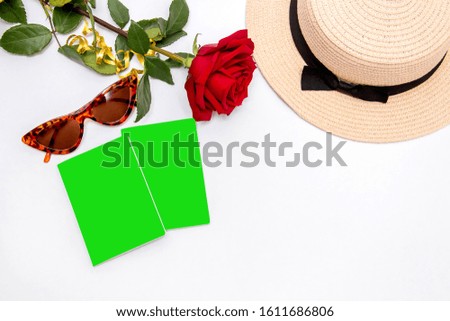 The model on a white background is a beautiful red rose, fashionable sunglasses, a sun hat, two passports. Top view with copy space. Travel for valentines day background concept. Chromekey