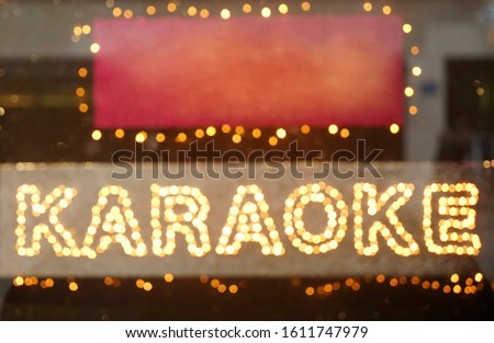 blurred image, photo. Neon Karaoke Sign. night colorful bokeh. Karaoke night neon sign on street wall background.