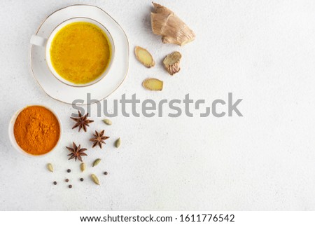 Ingredients for turmeric latte. Turmeric powder, curcuma root, cinnamon, ginger, badian over grey background, Spices for ayurvedic treatment. Alternative medicine concept.  Royalty-Free Stock Photo #1611776542