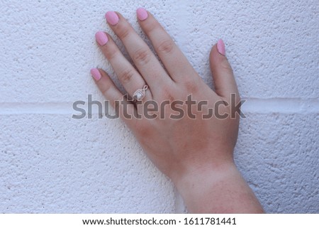 Pink manicured nails with engagement ring