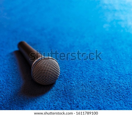 Microphone placed on a blue fabric with blur effect.