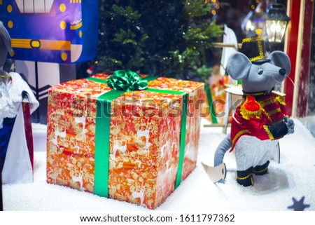 Christmas toy mouse, a symbol of the Chinese New Year. soft toy mouse stands near a gift bag