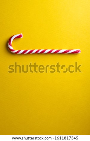 Peppermint candy canes on a yellow background.