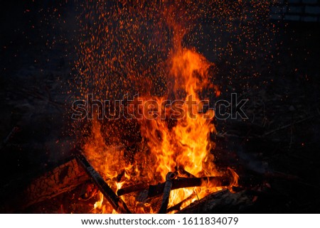 Big bonfire with sparks flying up, colorful space effect
