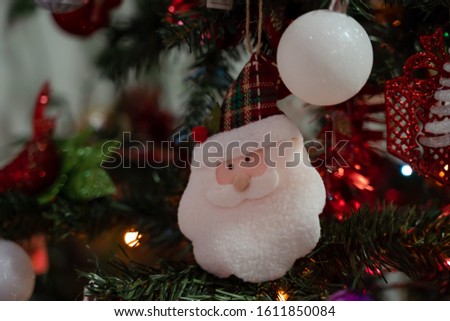 Santa doll and Christmas balls on the Christmas tree close-up