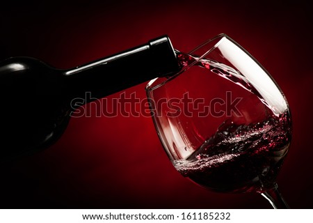 Bottle filling the glass of wine - splash of delicious flavor.