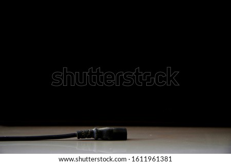 dirty old plug on the floor in the black background