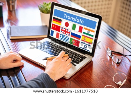 Online translation, foreign languages learning concept. Man working with a computer laptop, translate text on the screen.