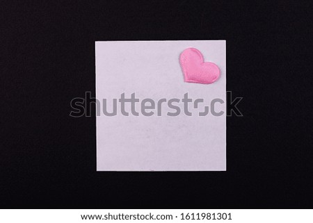 White sheet for notes with a pink heart on a black background