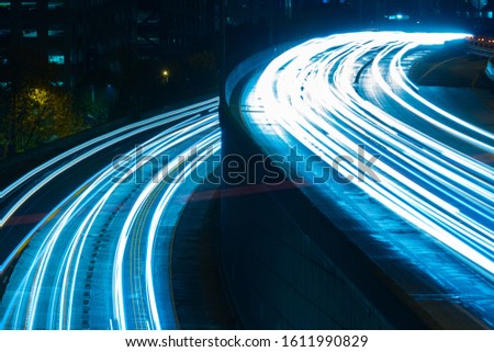 image showing two paths concept. high road and low road. high speed highway. blue teal tint. cars speeding by in long exposure with headlights on the road. 