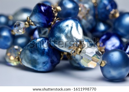 Macro abstract view of bright blue color vintage costume jewelry necklace beads on white background (with copy space)