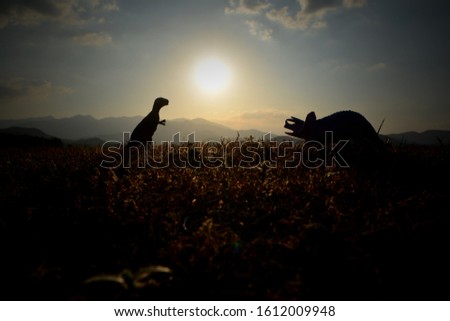 Dinosaurs in the evening meadow,picture silhouette