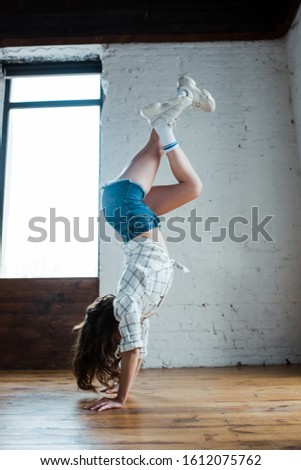 young dancer doing handstand in dance studio